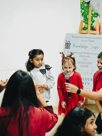 A teacher helps the young performers with their microphones during the Christmas show.