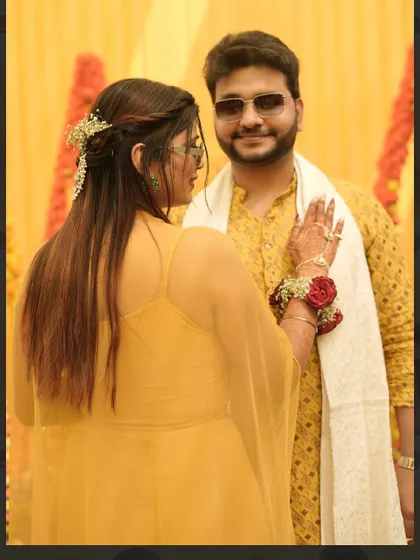 A sweet moment between the bride and groom during their Haldi ceremony. Her hair is styled with delicate flowers to match the festive vibe.