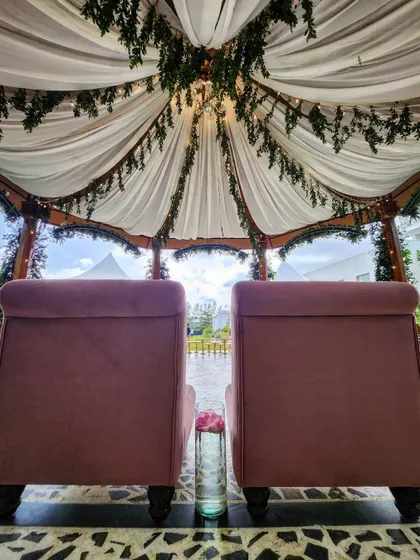 For this beautiful mandap, we provided a customized low seater for the couple. The plush pink chairs offer a comfortable and stylish focal point, perfectly complementing the draped canopy above.