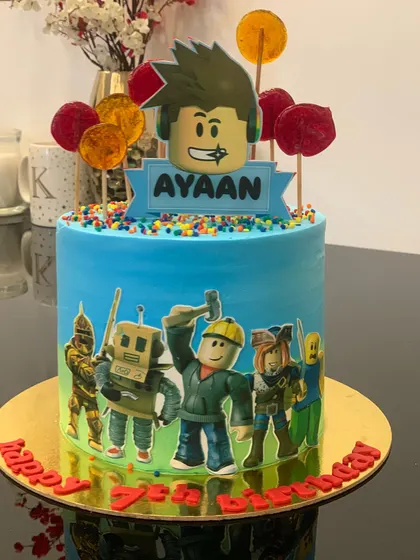 A vibrant Roblox cake for a 7th birthday. This design features an edible print of the game's characters around the side and is topped with a personalized gamer avatar.