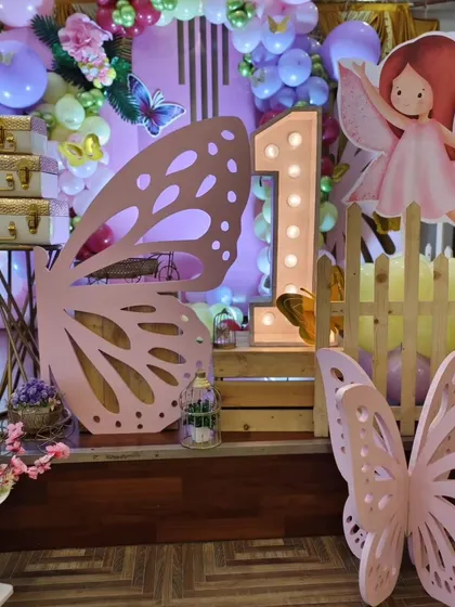 A large light-up number '1' next to a pink butterfly wing prop.