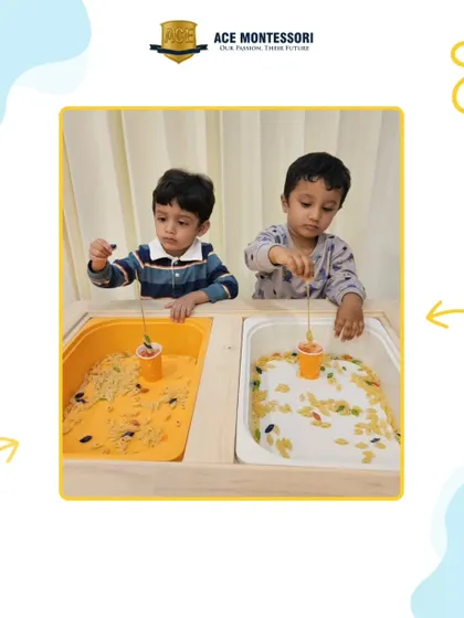 Two boys work side-by-side at the sensory table, using different tools to explore bins filled with rice and pasta. This parallel play is an important stage in social development.