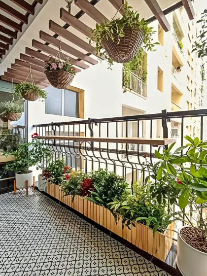 This balcony features a railing-mounted bar top, perfect for enjoying drinks with a view. The patterned floor tiles and hanging planters add a touch of classic charm.