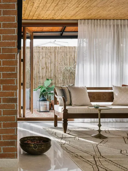 A living space from a modern colonial penthouse. The design blends an exposed brick wall with a light-filled, open layout for a relaxed yet sophisticated feel.