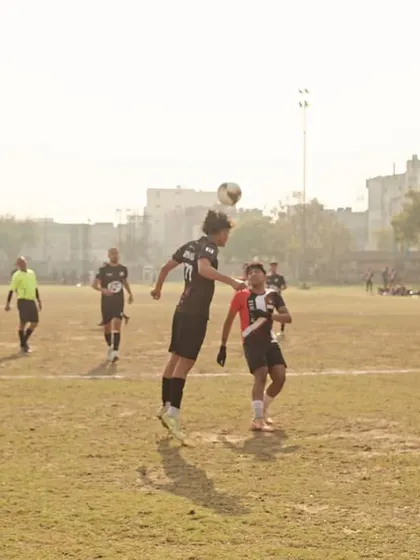 A player leaping high for a header, showcasing the athleticism and commitment we demand in every match.
