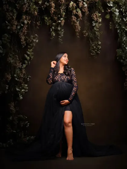 A beautiful portrait in a black lace gown, set against a lush, dark floral backdrop. This creates a romantic and slightly mysterious atmosphere.