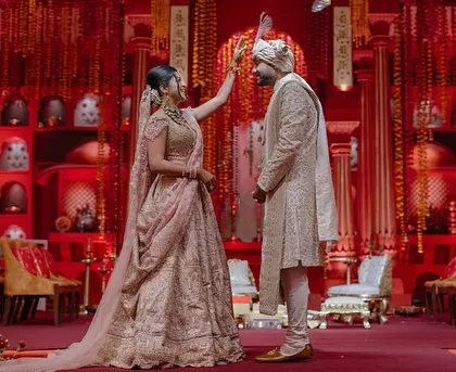 A beautiful ritual during the 'Lal Bagh' ceremony. Our design ensures that even in a grand setting, the focus remains on the couple and the sacred traditions they are observing.