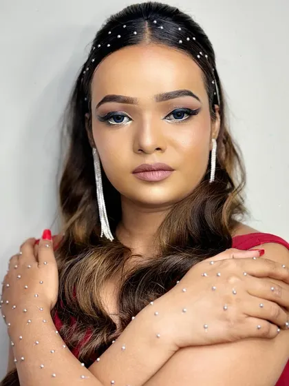 A dazzling cocktail party makeup look. The model is adorned with sparkling rhinestones on her hair and hands, paired with a sharp eyeliner and nude lips for a truly glamorous effect.