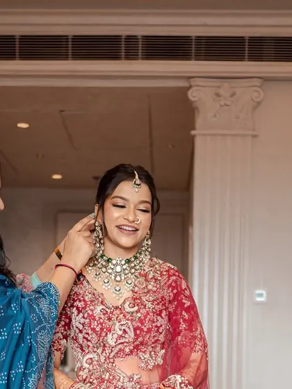 A quiet, intimate moment between the bride and her mother or sister, helping with the final touches of her jewellery. These getting-ready moments are filled with love and support.