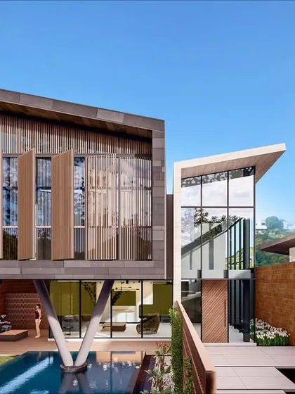 A render of an upcoming luxury villa complex in Pilerne, Goa. The architecture is bold and modern, with dramatic cantilevers, tree-like support columns, and a seamless connection to the outdoor pool and garden spaces.