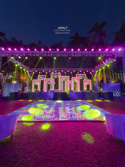 The full Sangeet stage and dance floor, with vibrant, colorful lighting creating an electrifying atmosphere.