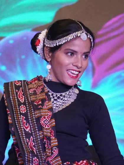 A joyful moment from a student's cultural dance performance, showcasing Sambalpuri fabric.