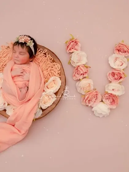 Spelling it out with flowers. A newborn wrapped in peach is the 'O' in the word 'LOVE', created with beautiful pink and white roses for a truly romantic and artistic shot.