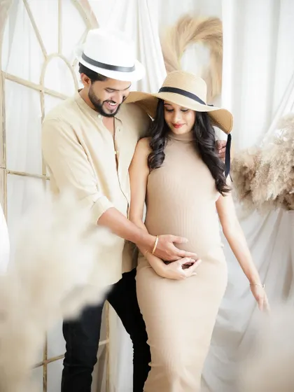 A stylish couple posing in matching hats and neutral tones. This shot has a chic, modern vibe that is perfect for fashion-forward parents-to-be.