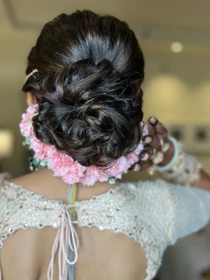 A different view of the pink carnation bun, showing the soft, woven texture of the hair.