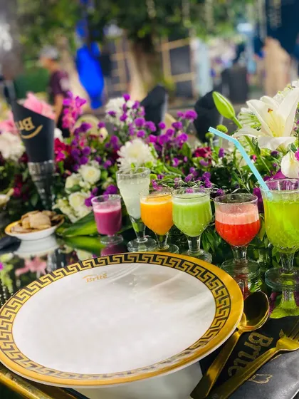 A close-up of the welcome drinks, placed next to custom-branded napkins and Versace-style plates.
