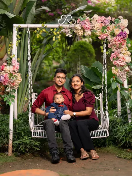 A picture perfect family portrait to frame forever. Seated on a beautiful floral swing in a lush garden, this family shares a sweet, composed moment. This session combined classic portraiture with a relaxed, outdoor setting for timeless family photos.