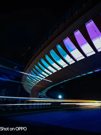 This long-exposure shot for an Oppo contest uses multi-colored lights on a bridge to create a dynamic and colorful image. The light trails from traffic add a sense of speed and energy.