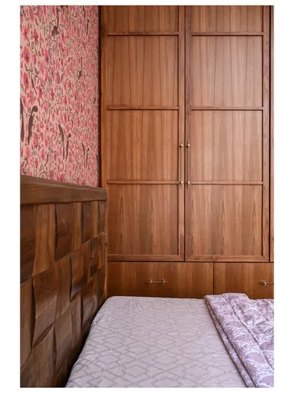 A closer look at the custom wooden wardrobe, showing the vertical grain and simple hardware.