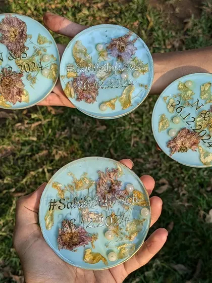 A group of four coasters, each preserving wedding flowers and personalized with the couple's hashtag and date. They make for a perfect, cohesive gift set.
