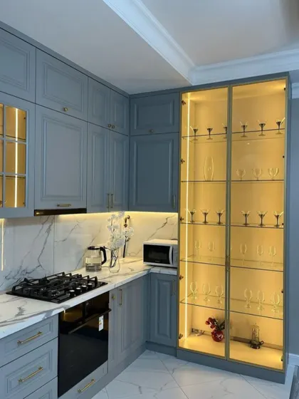 Another angle of the classic grey kitchen, providing a better look at the floor-to-ceiling glass display cabinet that serves as a stunning focal point.