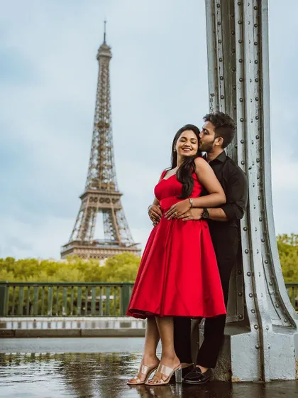 A tender moment between the couple on a bridge in Paris.