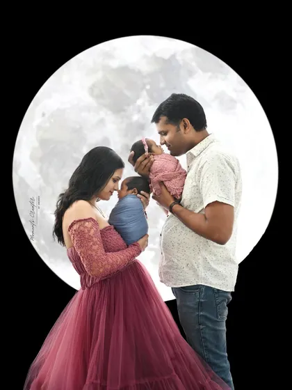 A magical portrait of a family with their newborn twins against a full moon backdrop. It's a creative and beautiful way to celebrate the arrival of two little stars.