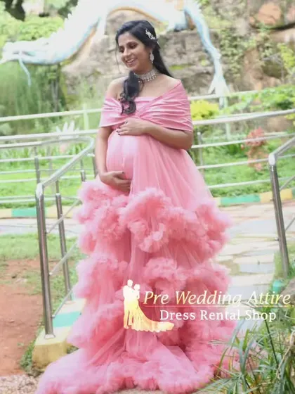 Our popular pink ruffled gown, captured from another angle to show its flattering off-the-shoulder neckline and voluminous skirt. A perfect choice for a classic and beautiful maternity shoot.