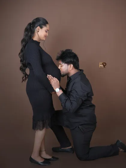 A classic pose filled with anticipation. The dad-to-be kneels to kiss the baby bump, a timeless and loving gesture that we love to capture for our couples.
