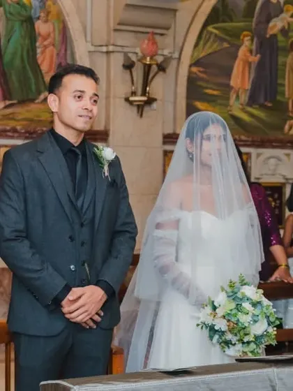 A wide shot of the couple at the altar, showing the serene and reverent atmosphere of the church wedding.