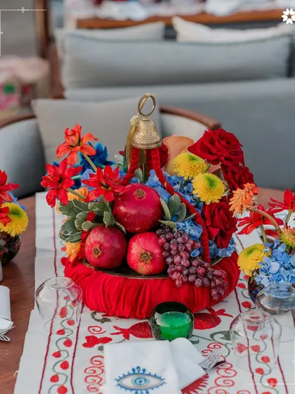 A vibrant centerpiece of pomegranates and colorful flowers from a wedding in Turkey. We love incorporating local and seasonal elements into our decor to create an authentic and culturally rich atmosphere.