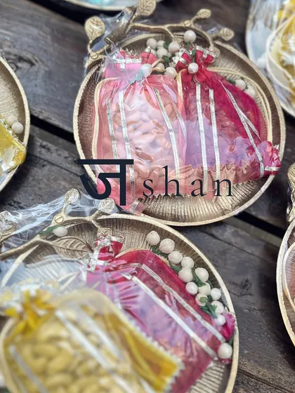 My "Jashn" collection for Diwali, featuring dull gold decor platters, colorful organza potlis filled with roasted nuts, and personalized gold-foiled tags.