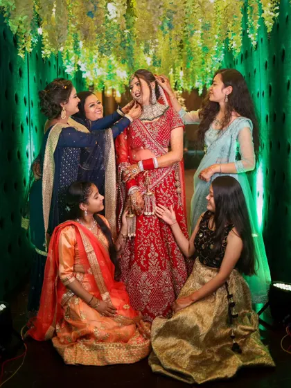 A fun and interactive group photo of the bride and her bridesmaids. Their playful adjustments and happy expressions make for a lively and memorable shot.