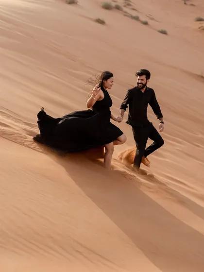 Capturing movement and joy as the couple runs down a sand dune. The flowing dress and the golden light create a beautiful, dynamic image full of life.