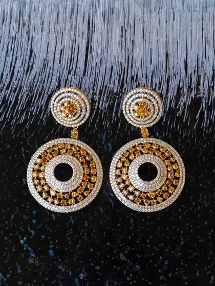 Can you freeze diamonds? Not really, but shooting on ice creates a fantastic texture. These diamond and yellow sapphire earrings for Jalak Jewels look extra brilliant against the frosty, dark background.