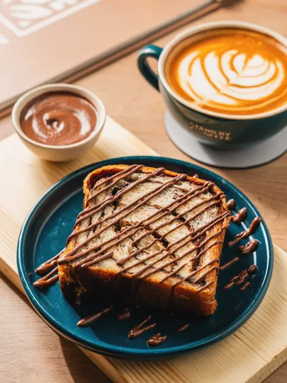A comforting pairing of French toast with chocolate sauce and a cappuccino. We style shots to evoke feelings of warmth and indulgence.