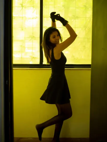 A playful, dancing pose in the black dress and gloves, showing a shift from the moody vibe to a more joyful one.