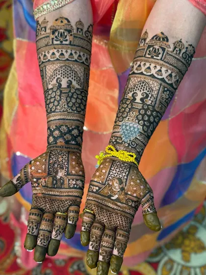 A perfect example of symmetrical bridal mehendi, where both hands mirror each other beautifully. This design features classic bride and groom portraits, intricate peacocks, and traditional architectural motifs for a timeless look.
