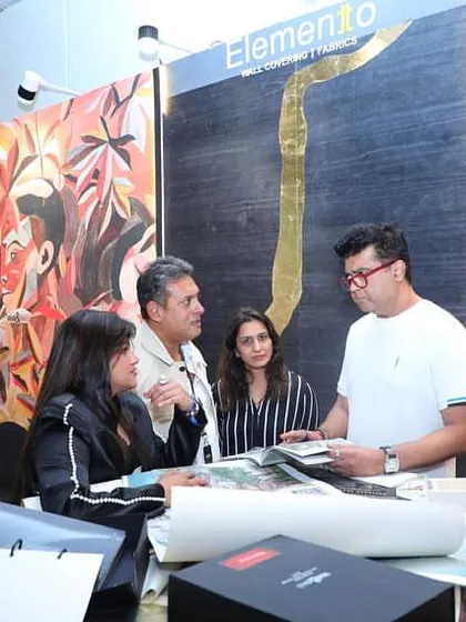 A group of designers and clients gathered at our booth during the Ajio Luxe Weekend, deep in conversation over our wallpaper and fabric books.
