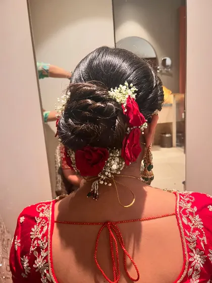 The charm of a floral wedding bun is unbeatable. This one features red roses and baby's breath for a classic bridal look.