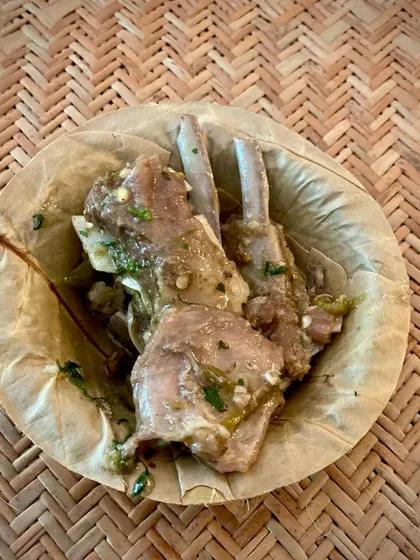Tender mutton chops served in a leaf 'donne' at the 'We The Chefs' event. This simple presentation keeps the focus on the flavour of the meat.