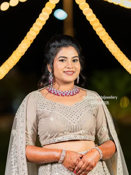 A smiling portrait of the bride, looking confident and beautiful in her reception jewellery.