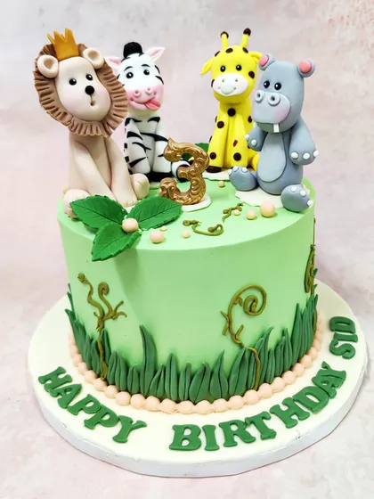 We gather the whole jungle crew for this vibrant safari cake. A crowned lion, a cheeky zebra, a friendly giraffe, and a happy hippo are handcrafted to sit atop a lush green cake, perfect for a wild animal-themed birthday adventure.