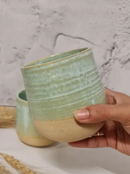 Holding one of my handcrafted tumblers. The throwing rings are visible, adding to the texture and handmade feel of the piece. These are made to last a lifetime.