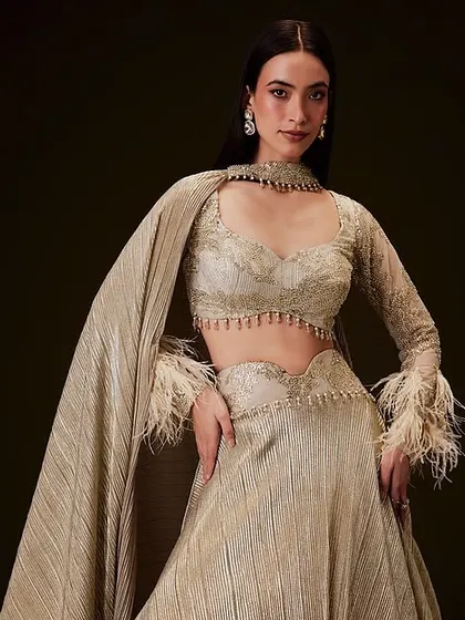 A full-length view of the modern lehenga with a cape. The sleek hair and glam makeup complete this high-fashion ethnic look.