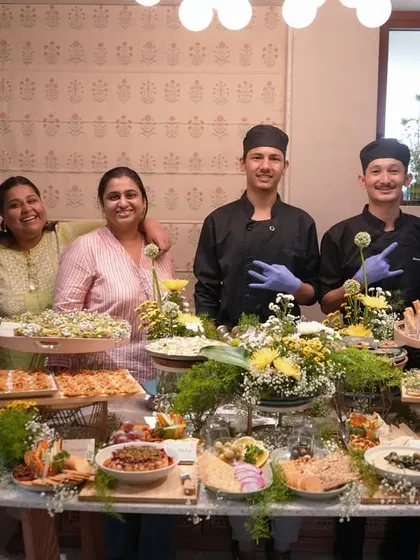 Meet the heart of our operations. This photo shows our dedicated team of chefs and founders, Khyati and Pooja, proudly standing behind a festive grazing table, ready to make your event a memorable one.