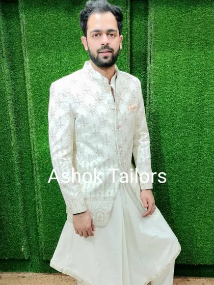 A customer trying on our white Indo-Western outfit. The jacket has light embroidery, and it's paired with a draped dhoti-style bottom for a fusion look.