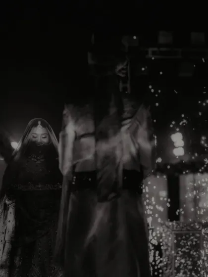 An artistic, moody black and white shot of the couple on stage, with a sense of mystery and drama.