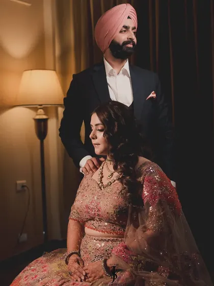 A quiet, romantic moment. The warm lighting highlights the beautiful details of her floral Sangeet lehenga.