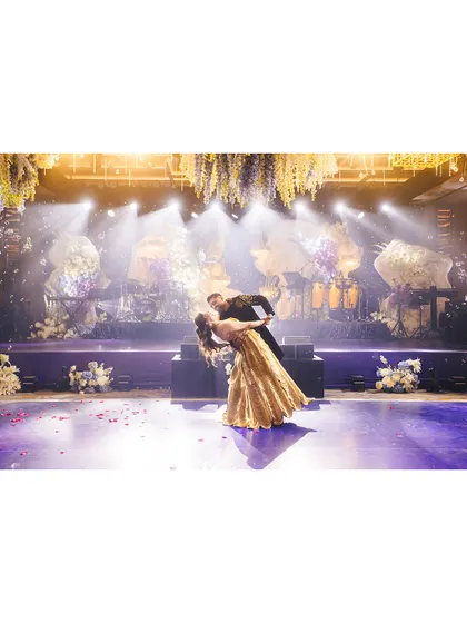 A classic dip at the end of a romantic dance. The dramatic lighting and stage setup make this a picture-perfect moment from the Sangeet night.